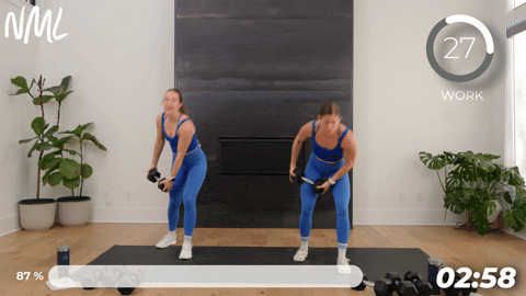 two women performing a woodchops with dumbbells.