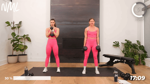 two women performing tempo squats with dumbbells in a leg and chest workout