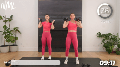 two women performing an alternating shoulder press with dumbbells.