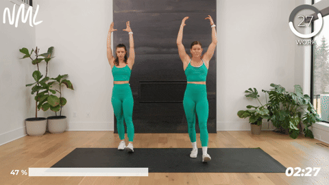 2 women performing hamstring scoops as part of pre running stretches