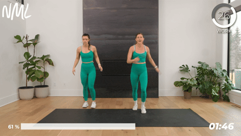 2 women performing alternating leg swings as part of pre running stretches