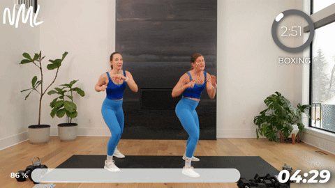 two women performing a jab and double knee block in a boxing workout at home