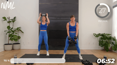two women performing burpees with dumbbells.