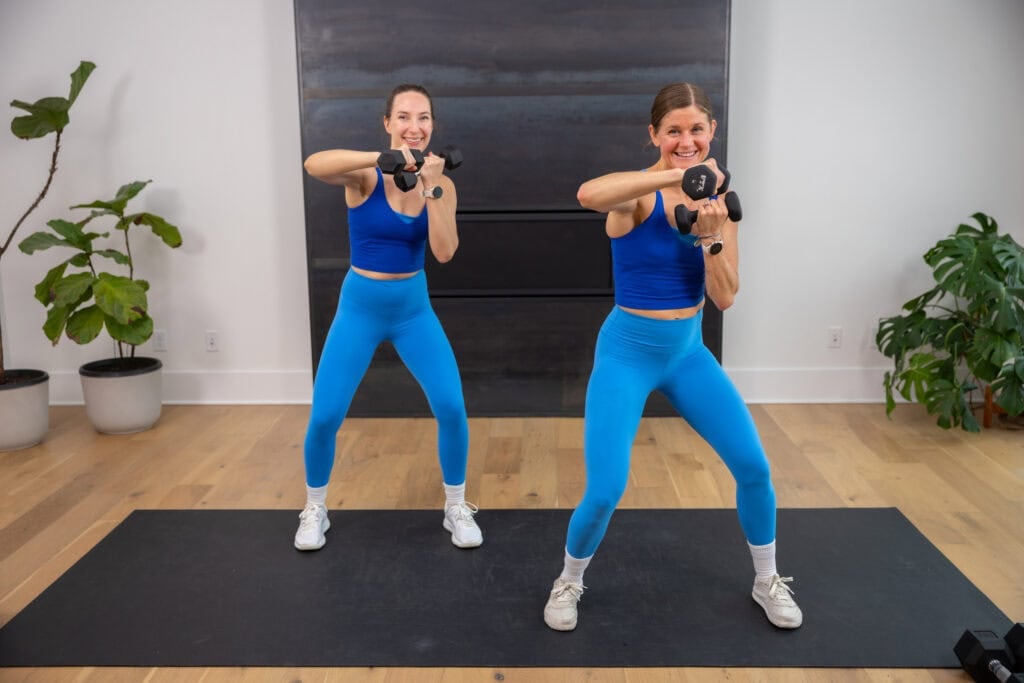 two women performing an elbow block in a boxing workout at home