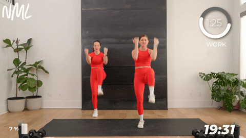 two women performing high knees into standing crunches as part of a walking workout