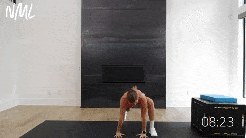 A woman doing a runner's lunge on a black mat.