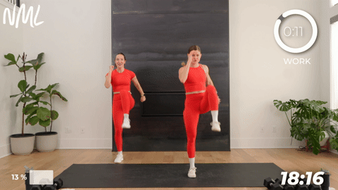 two women performing a bodyweight squat and knee drive in a walking workout