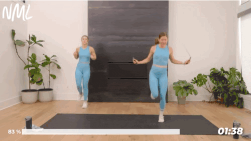 Two woman working out doing 5 count single leg switches with a jump rope.