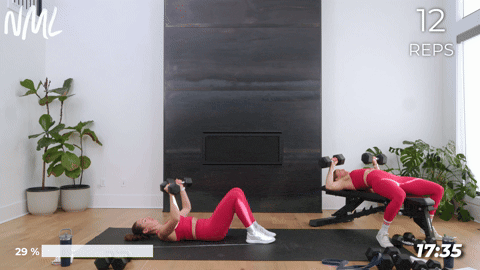 One women performing chest press laying on the floor and one women performing chest press on a bench.