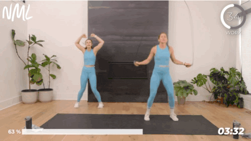 Two woman working out doing jack jumps with a jump rope.