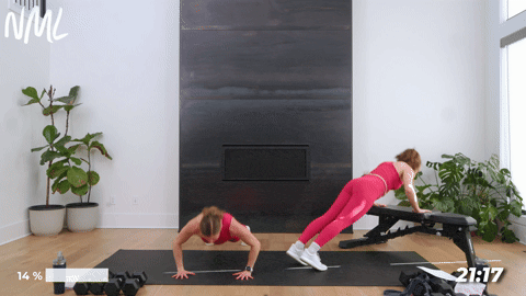 One women performing standard push ups and one women performing incline push ups on a bench.
