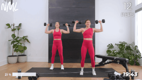 Two women performing a shoulder press as part of a chest and arm workout.