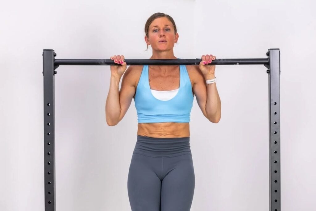 A woman doing a pull up bar work out.